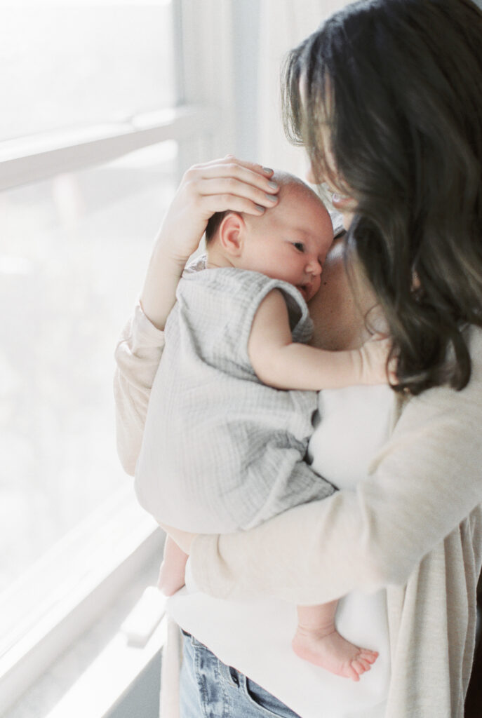 baby snuggled with his mother by Orlando baby photographer