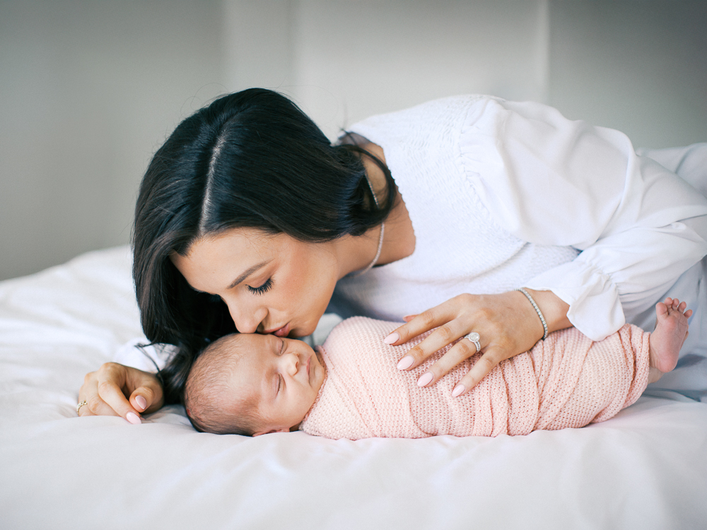 Mother kissing her brand new baby girl by Orlando newborn photographer