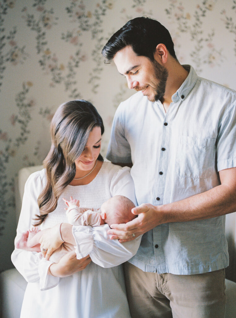 Parents with newborn in her beautiful nursery by Orlando Newborn Photographer