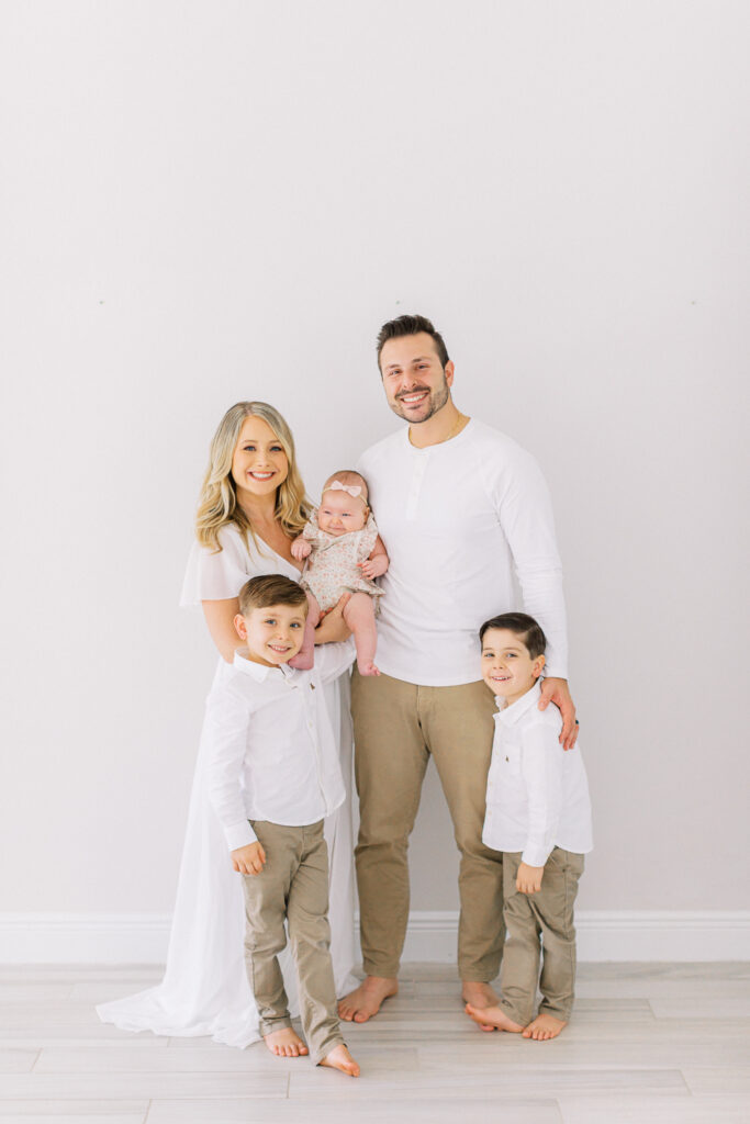 Happy family at home with newest sibling by Orlando newborn photographer.