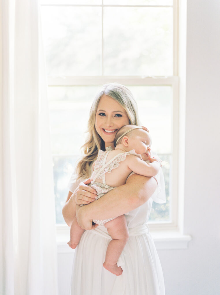 Sun drenched image of a mother with her new baby girl at home.