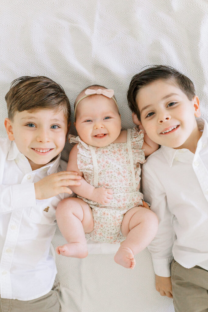Siblings with new baby sister by Orlando family photographer.