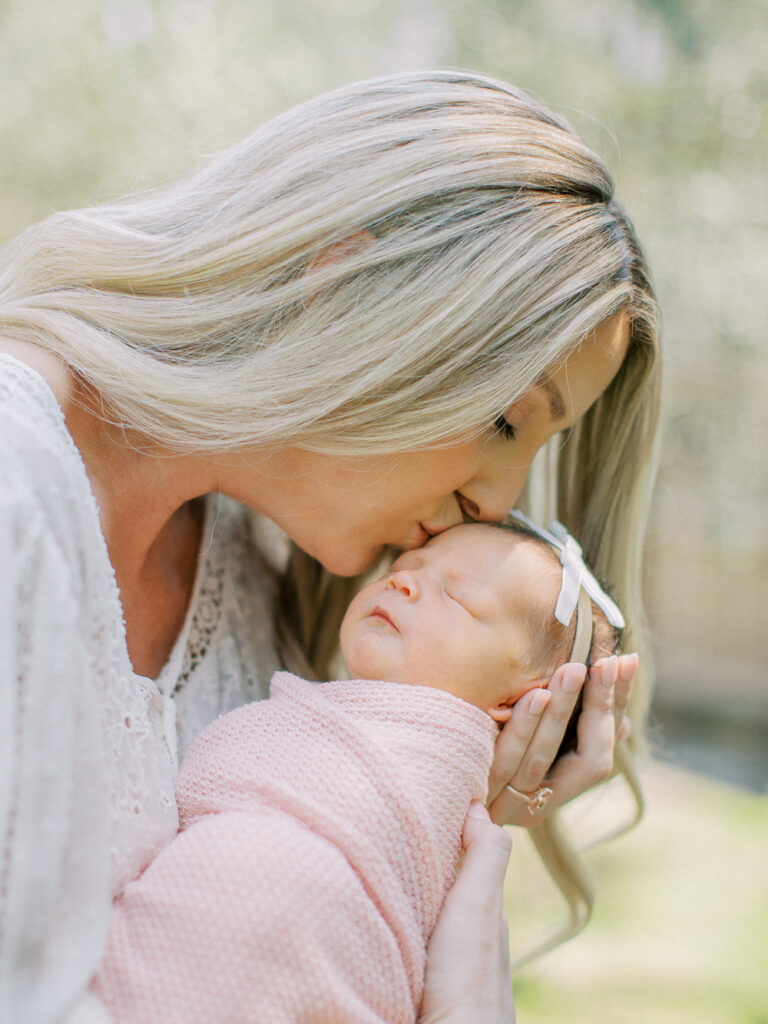 Mom cuddling newborn baby during in-home Orlando session, showing intimate family connection