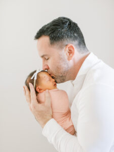 Dad snuggling newborn baby at lifestyle newborn session in Winter Park, FL