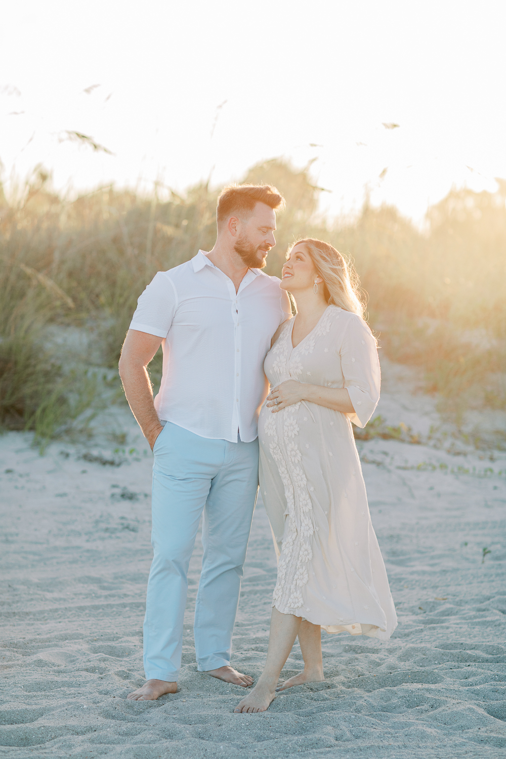 Intimate moment of parents-to-be during beach photography session in Orlando