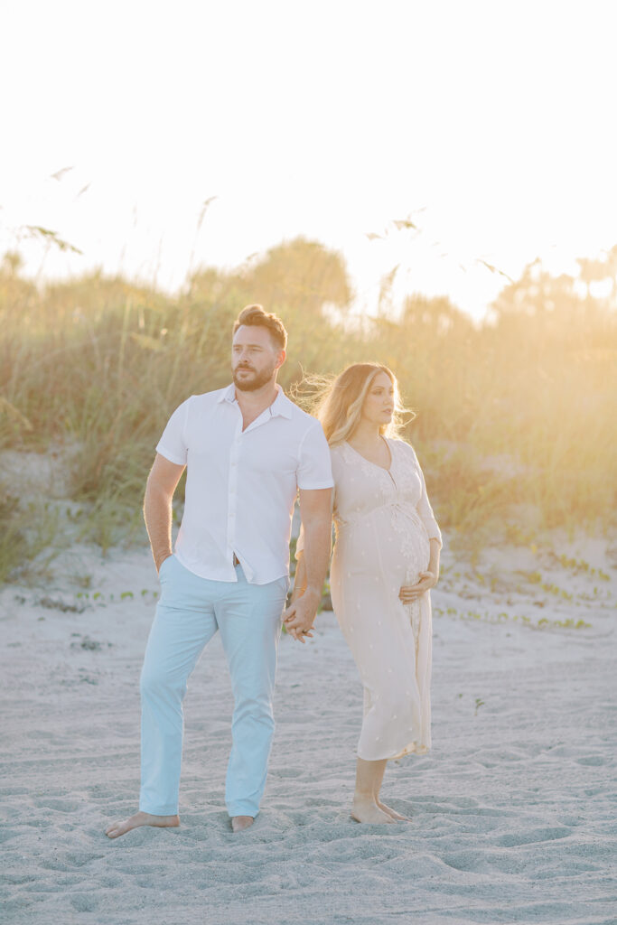 Editorial style maternity photo of parents-to-be during beach photography session in Orlando