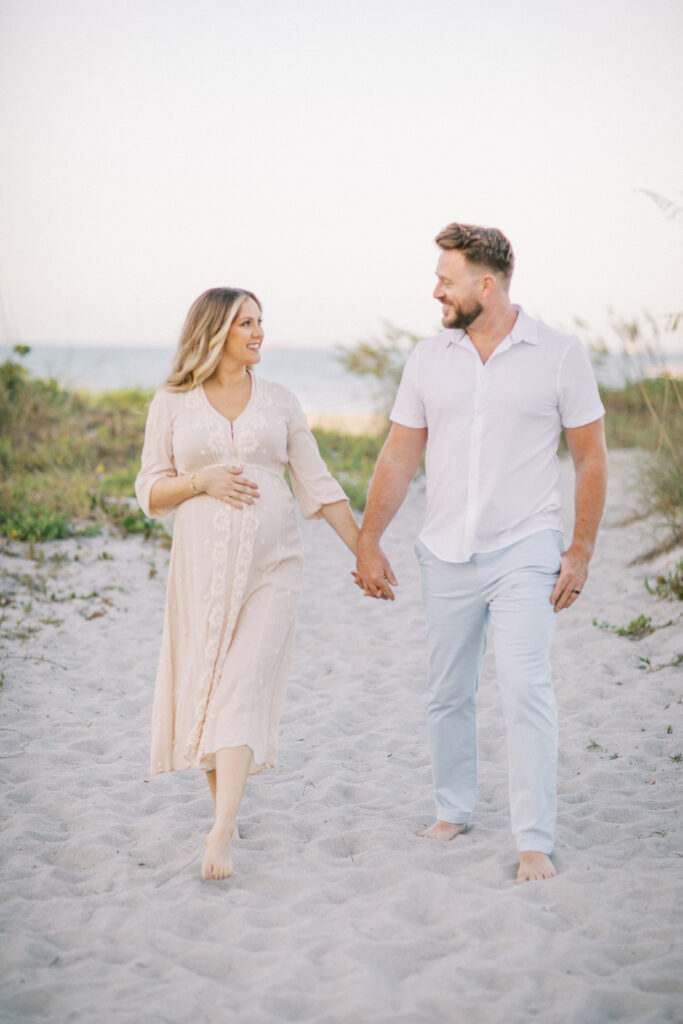 Candid maternity photo of parents-to-be walking during relaxed photography session in Orlando