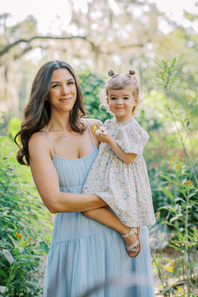 Mother holding her 2-year-old close in the soft morning light.