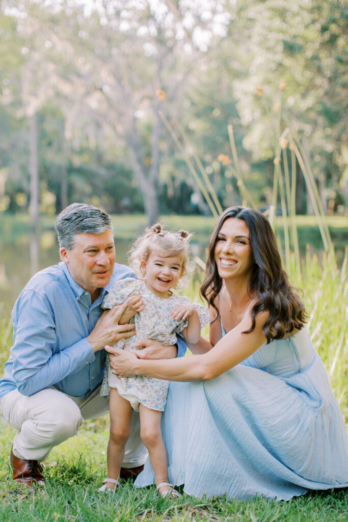 Candid moment of toddler laughing while parents look on happily.