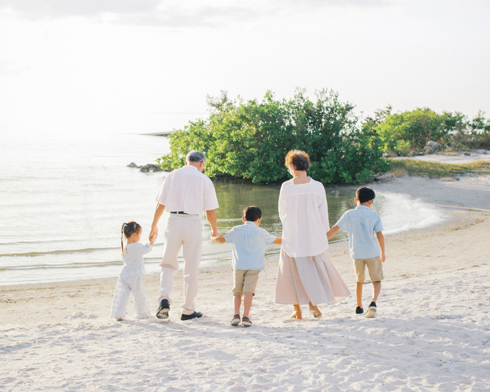 Grandparents and grandchildren sharing a candid moment during a beach family shoot in central Florida.