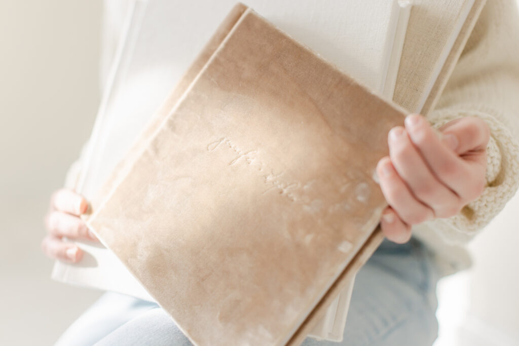 Hands holding the Heirloom Album, showcasing its timeless design and elegant cover.
