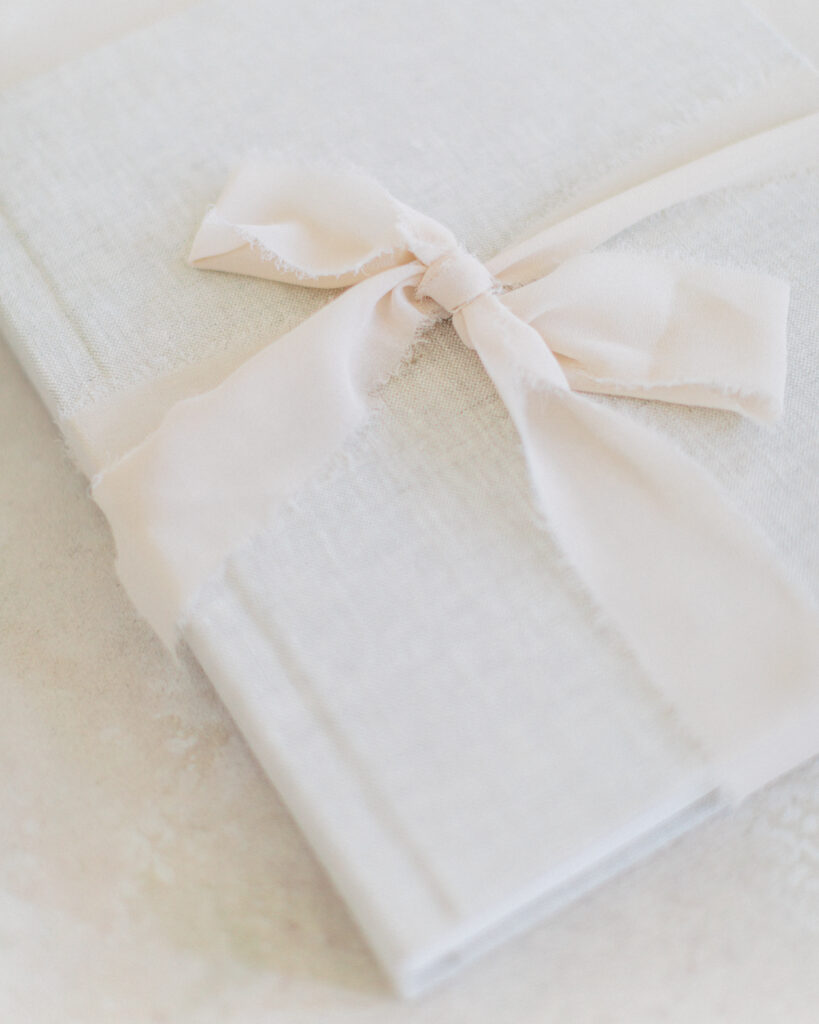 The Heirloom Album styled as a holiday gift with ribbon and evergreen accents, featured in The Scout Guide’s 2025 Gift Guide for Her.