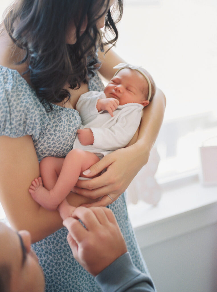 Orlando in-home newborn session in a cozy nursery with a mother holding her baby.