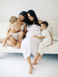 Family snuggling on couch and awaiting new baby by Orlando in home photographer.