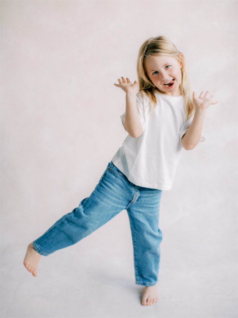 Little girl in white and denim showing off her poses.