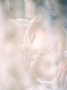 Mother nursing baby creative light filled photograph.