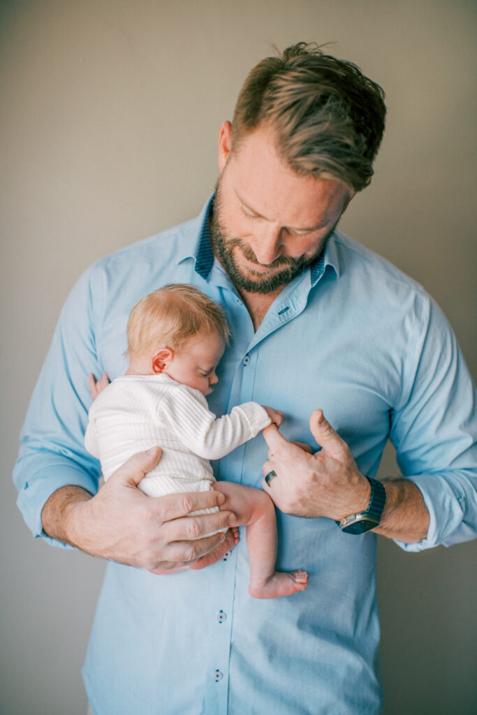 Dad with baby in a light filled in home newborn session. 