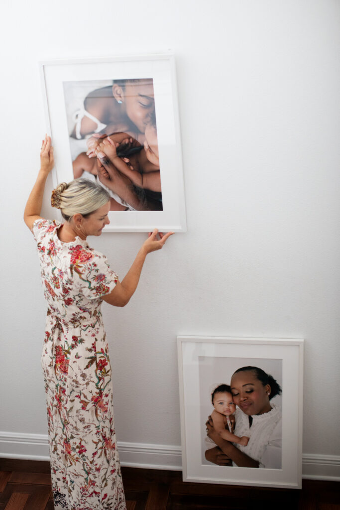 Orlando maternity photographer installing framed art into a client's home.