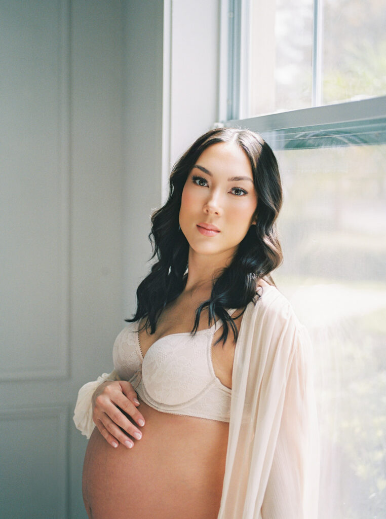 A luminous mother to be in window light at home.